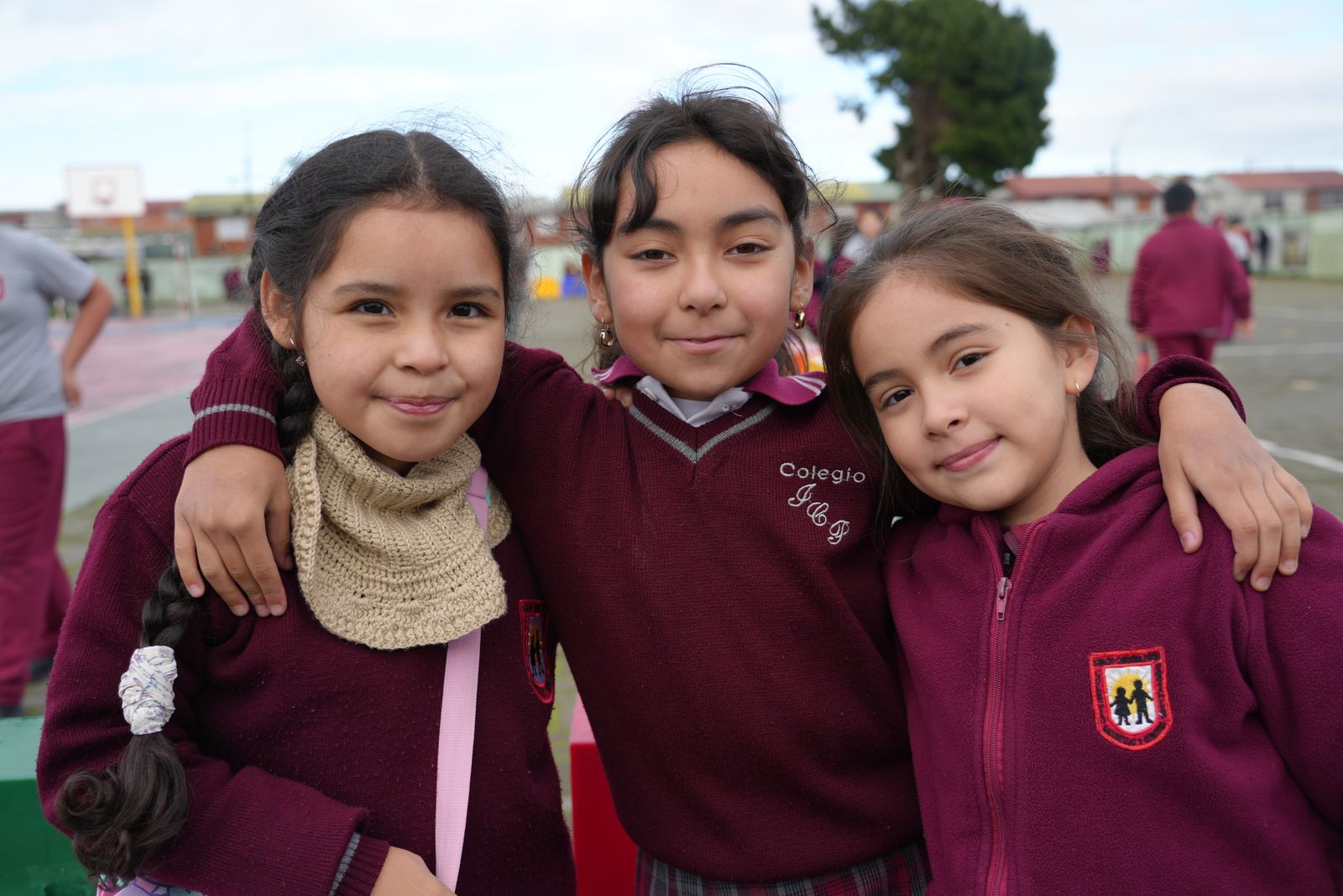 Estudiantes del Colegio Ignacio Carrera Pinto compartiendo y sonriendo en el patio durante el recreo